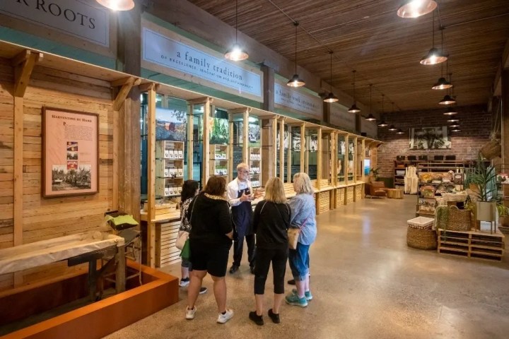 People gathered inside a rustic store with wooden decor and display shelves.